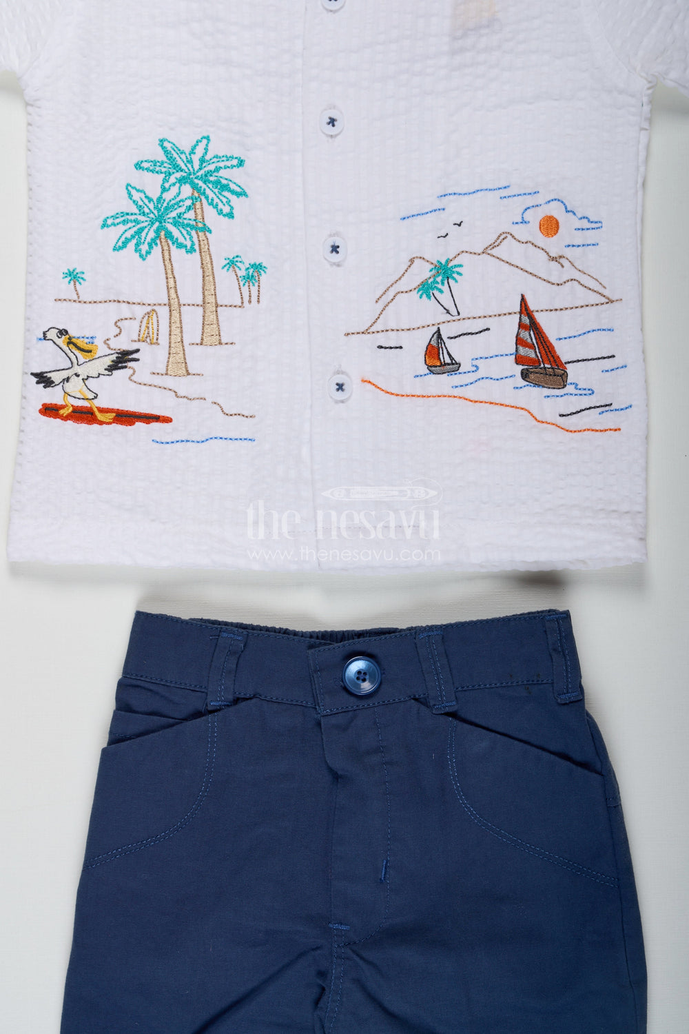 The Nesavu Boys Casual Set Thread Embroidery Boys Casual Shirt Set with Beach Scene Motif and Navy Blue Shorts in Crush Cotton Blend Nesavu Nesavu Thread Embroidery Boys Shirt Set with Beach Motif in Crush Cotton and Navy Blue Shorts