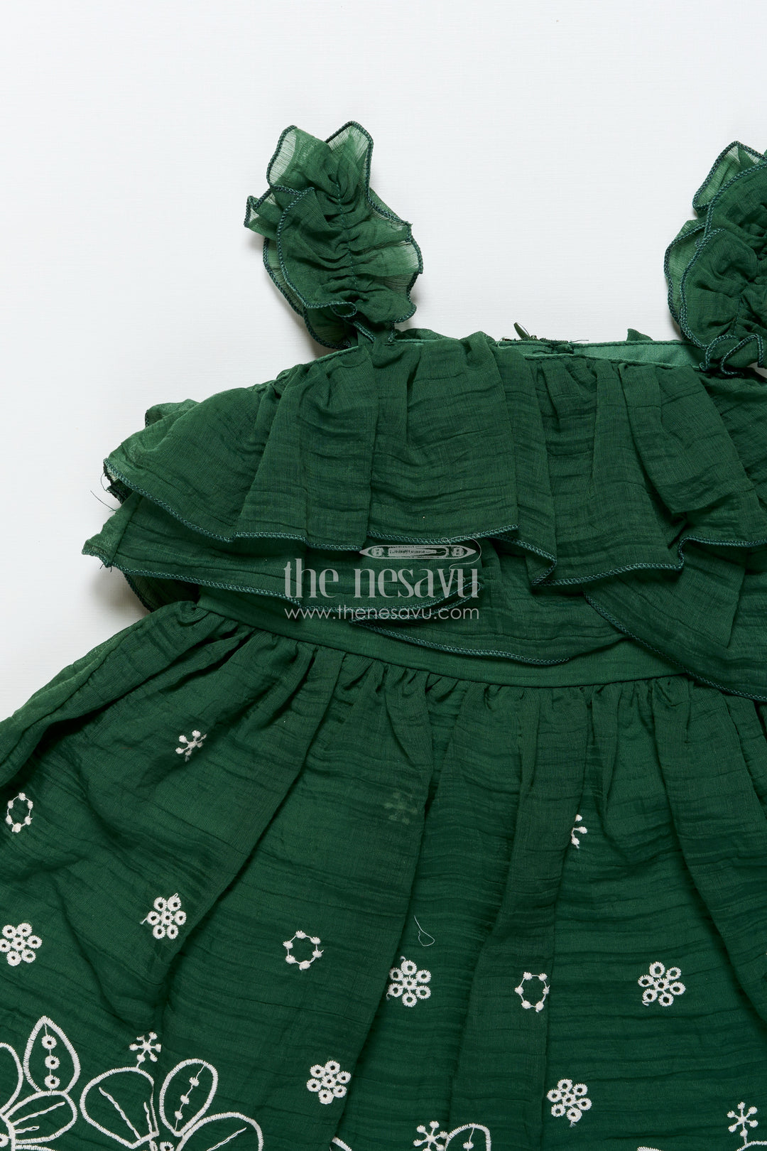 Temple visit baby frock in traditional green with soft cotton fabric and intricate floral lace accents