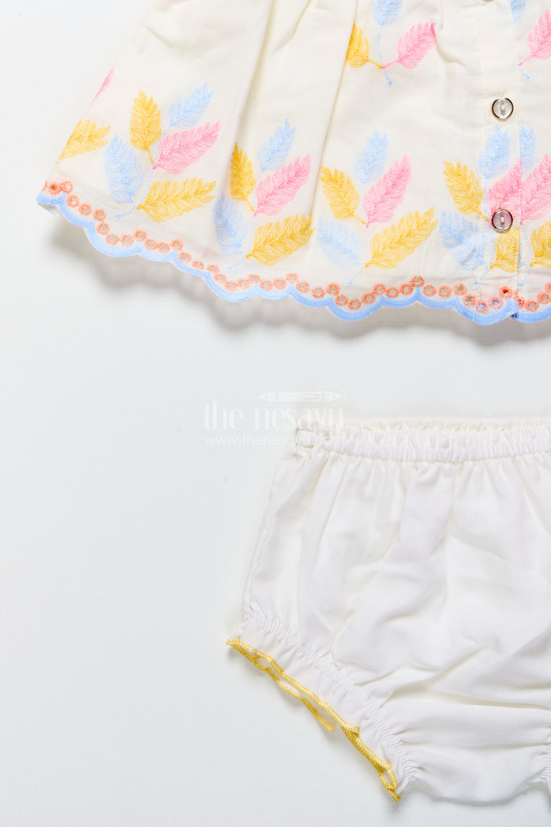 Cream baby frock with pastel thread embroidery and flower patch