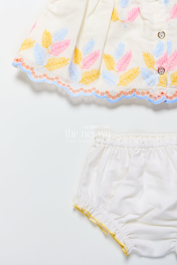 Cream baby frock with pastel thread embroidery and flower patch