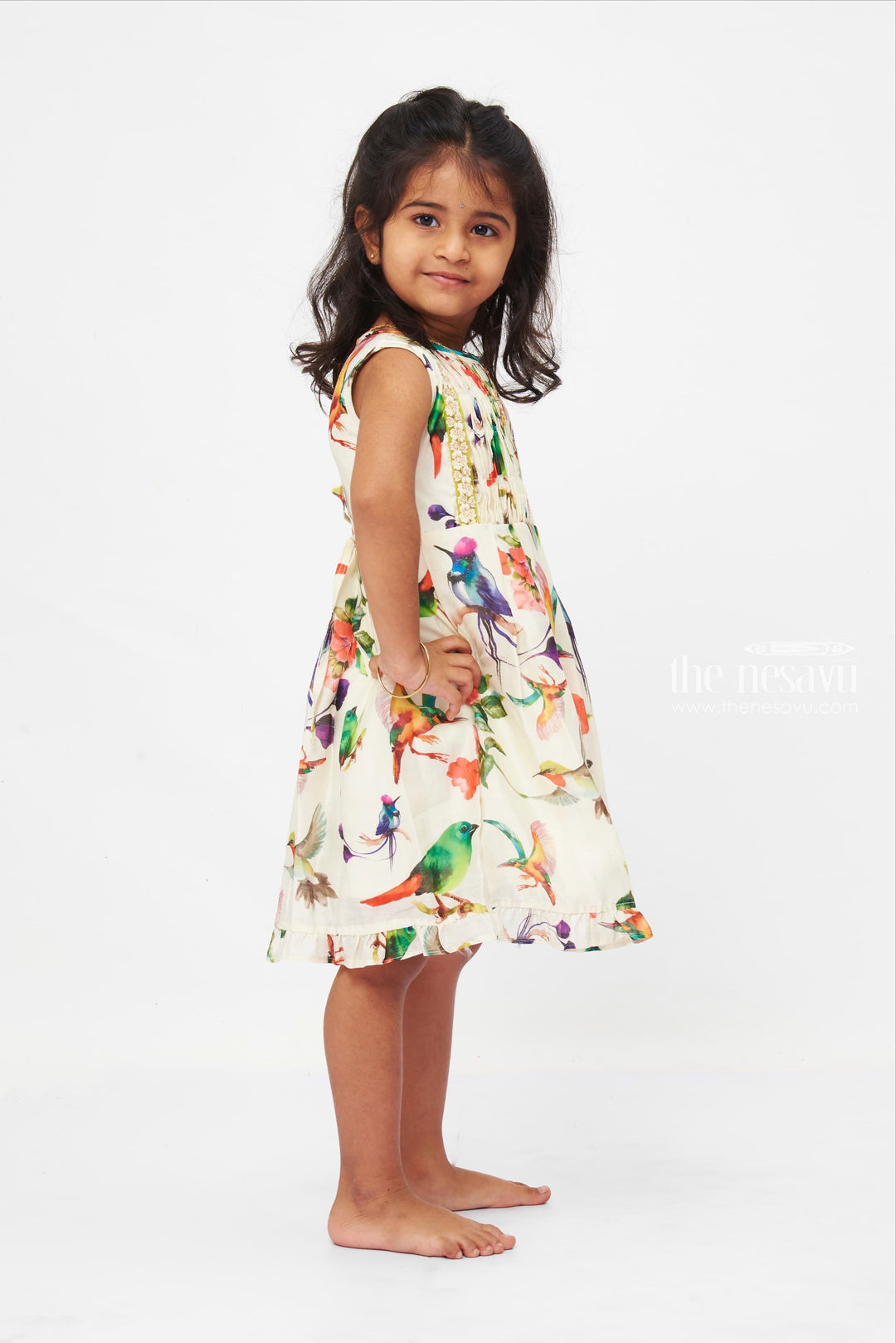 The Nesavu Girls Cotton Frock Avian Paradise Sleeveless Dress: Vibrant Bird & Floral Print Frock for Girls Nesavu Colorful Bird Print Girls Dress | Floral Sleeveless Summer Frock | Playful Ruffle Hem | The Nesavu