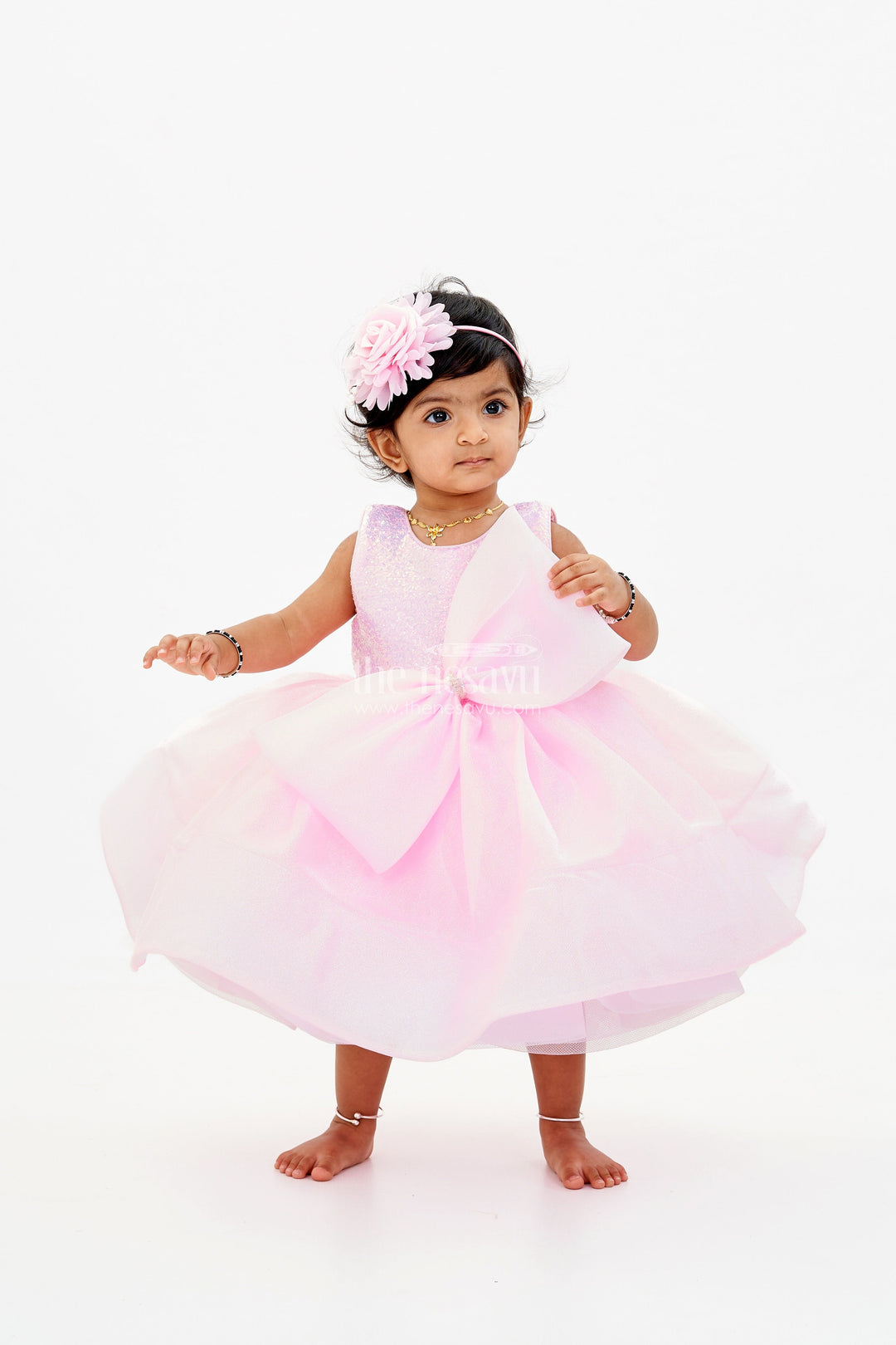 The Nesavu Baby Fancy Frock Baby Girls Fancy Frock in Pink Shimmer Fabric with Oversized Bow and Flared Silhouette Nesavu Nesavu Baby Girls Fancy Frock Pink Shimmer Fabric Oversized Bow Flared Skirt