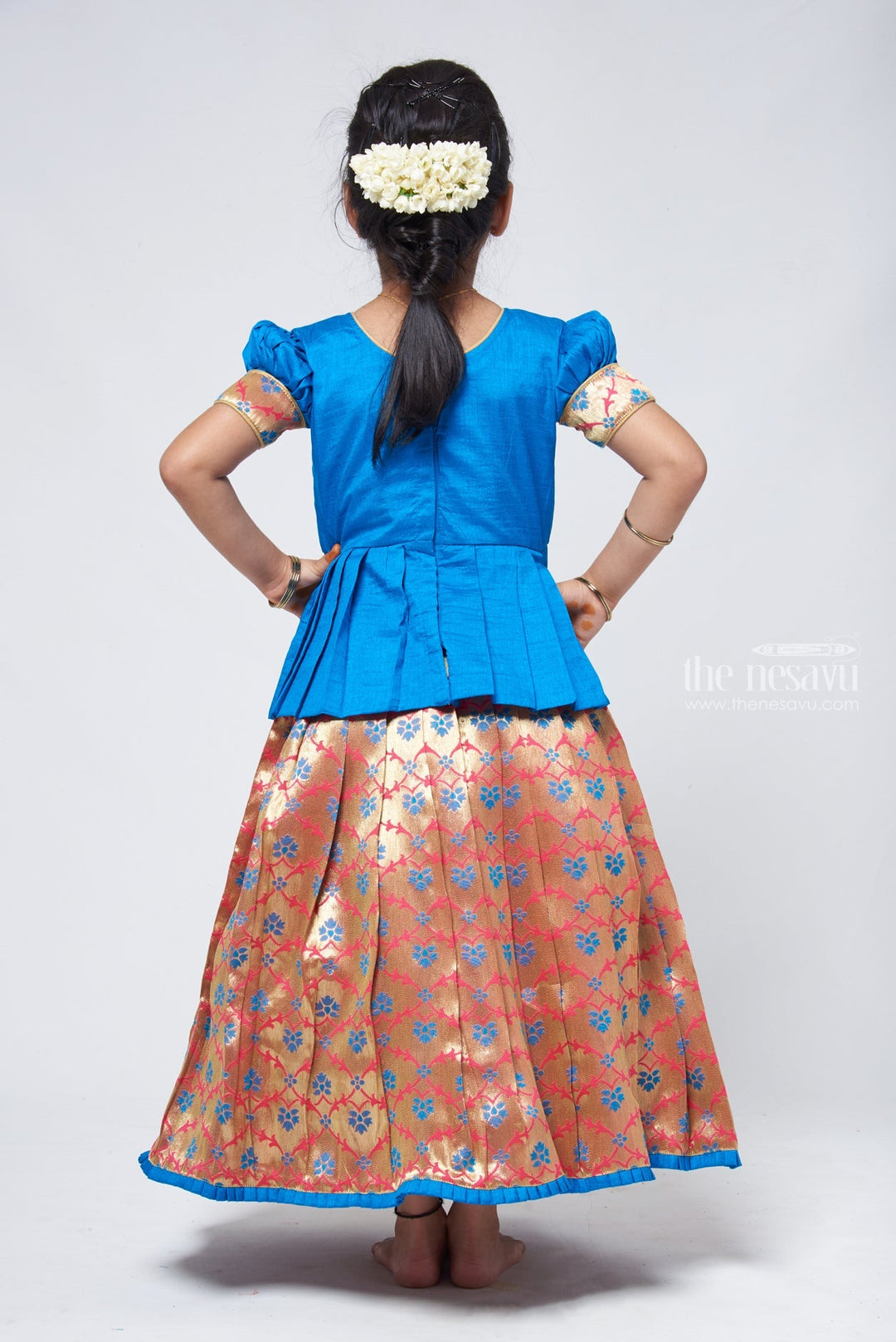 The Nesavu Pattu Pavadai Charming Blue Silk Peplum Blouse with Zari Floral Pattu Pavadai: Perfect Celebration Wear for Girls Nesavu Silk Blouse with Zari Floral Pattu Pavadai | Traditional Pattu Pavadai | The Nesavu