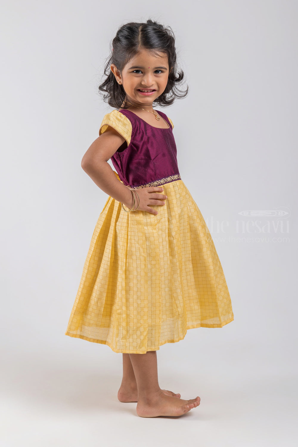 The Nesavu Silk Embroidered Frock Checkered Pattern Yellow Semi Silk Frock with Purple Yoke for Girls psr silks Nesavu