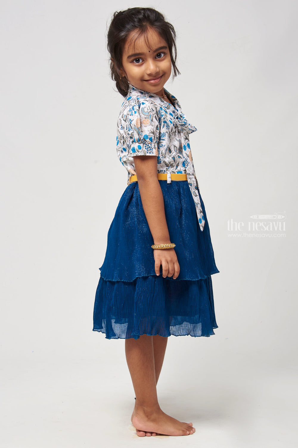 The Nesavu Frocks & Dresses Double Layer Flared Blue Frock - Floral Tie Neck Design Nesavu Floral Printed Fancy Frock | Latest Frocks for Girls | The Nesavu Elevate your childs wardrobe with our Floral Printed Tie Neck with Double Layer Flared Blue Frock. The floral print adds elegance, while the sleeveless design ensures comfort. The tie neck detail adds a stylish touch, and the double layer flared skirt creates a graceful look.