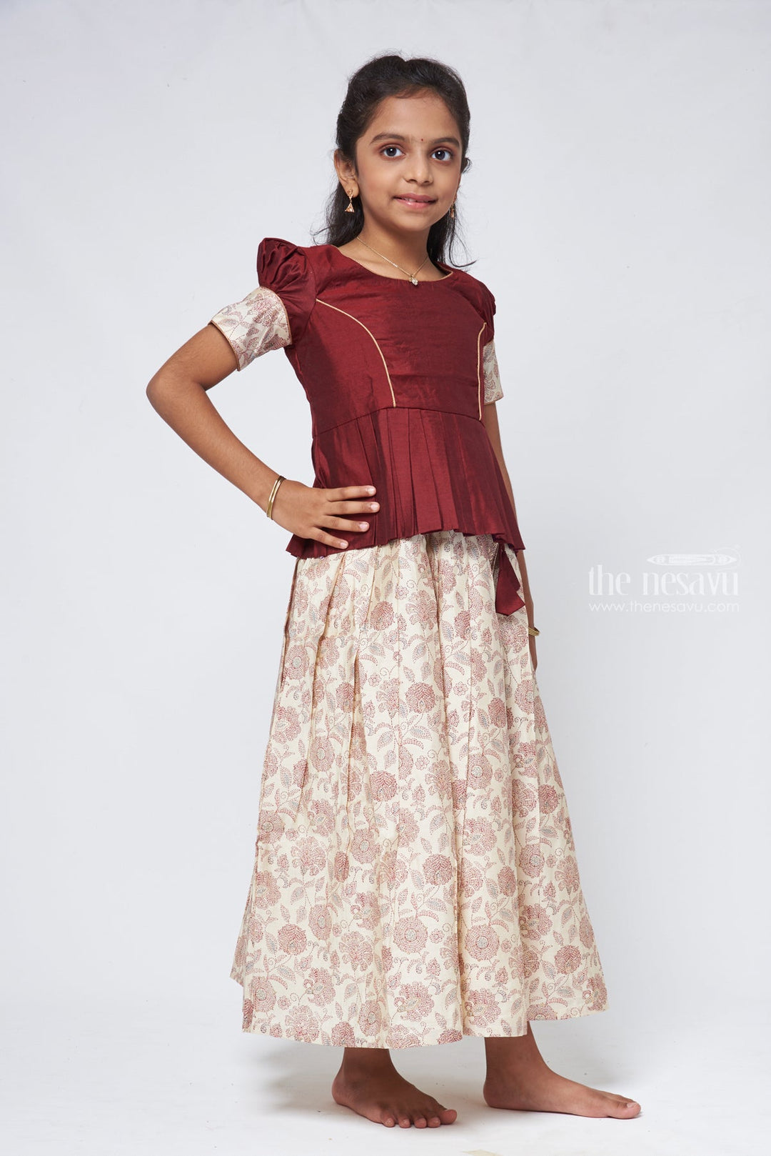 The Nesavu Pattu Pavadai Floral Printed Pleated Beige Skirt with Box Pleated Brown Jacquard Silk Blouse for Girls Nesavu Latest Pattu Pavadai Designs | Girls Pattu Langa | The Nesavu