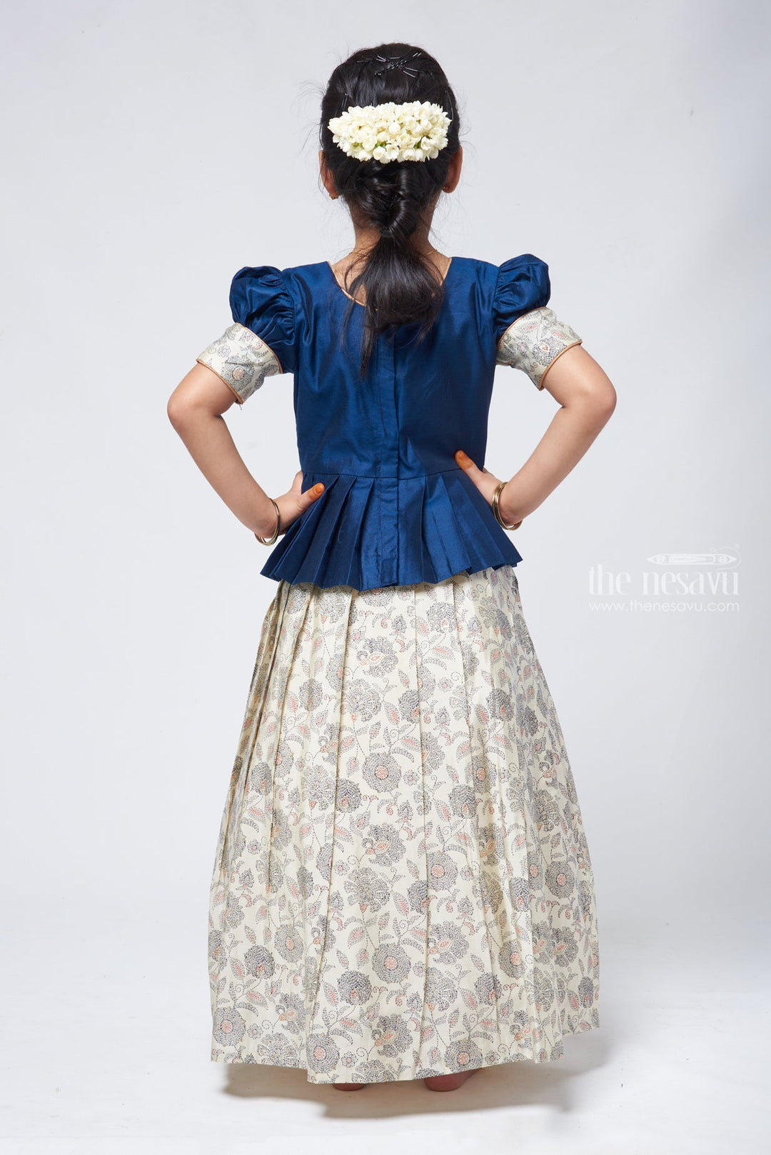 The Nesavu Pattu Pavadai Floral Printed Pleated Beige Skirt with Box Pleated Navy Blue Jacquard Silk Blouse for Girls Nesavu Latest Pattu Pavadai Design | Girls Pattu Langa | The Nesavu