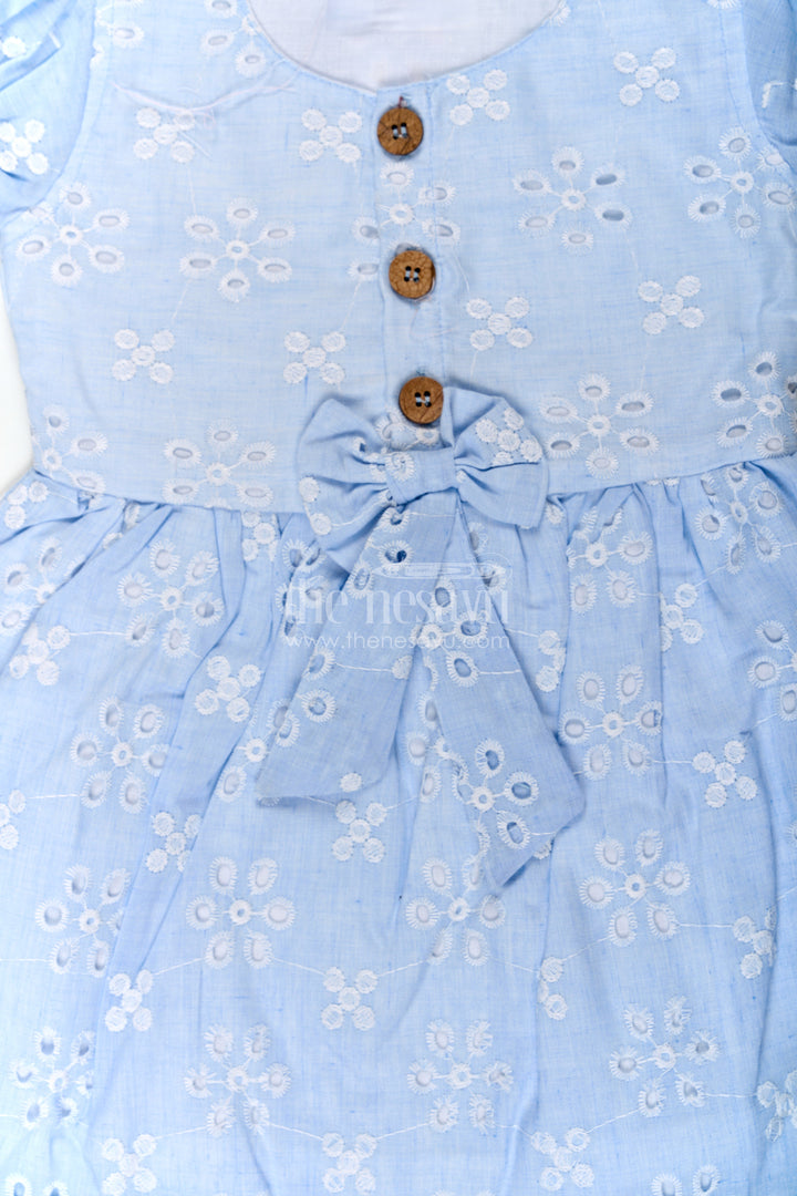 The Nesavu Girls Cotton Frock Girls Casual Wear Party Dress in Sky Blue Hakoba with Bow Belt and Wooden Button Detail Nesavu Nesavu Casual Wear Party Dress for Girls in Sky Blue Hakoba with Embroidery and Waist Bow