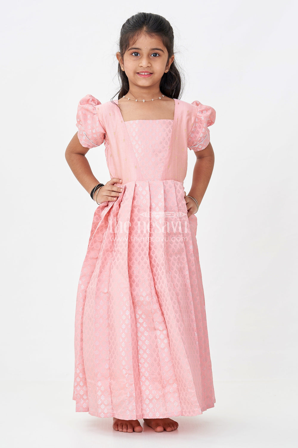 The Nesavu Girls Silk Gown Girls Semi Banaras Silk Pink Party Wear Gown with Intricate Woven Motifs and Classic Puff Sleeves Nesavu Girls Semi Banaras Silk Pink Party Wear Gown Floral Woven Design Puff Sleeves | The Nesavu