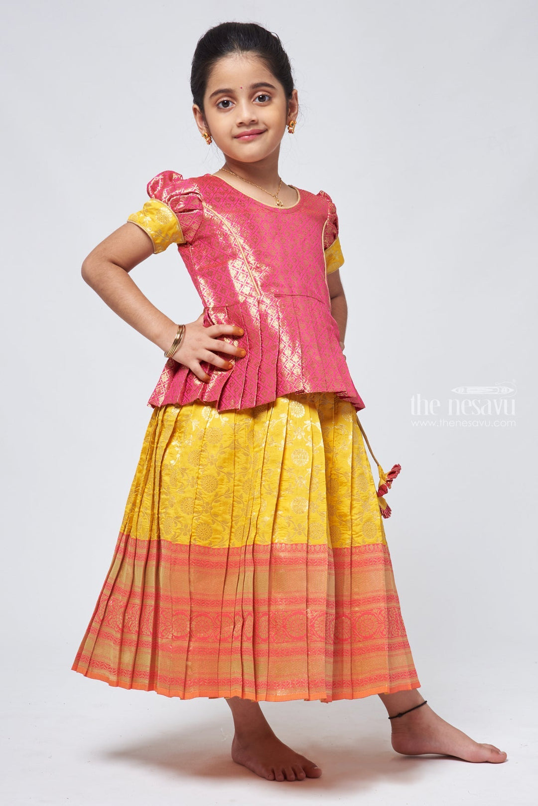 The Nesavu Pattu Pavadai Langa Brocade Peplum Blouse paired with Banarasi Pattu Pavadai Chattai - Traditional Silk Dress for Girls Nesavu Traditional Girls Pavadai Sattai | Langa Voni Pattu Pavadai For Girls | The Nesavu