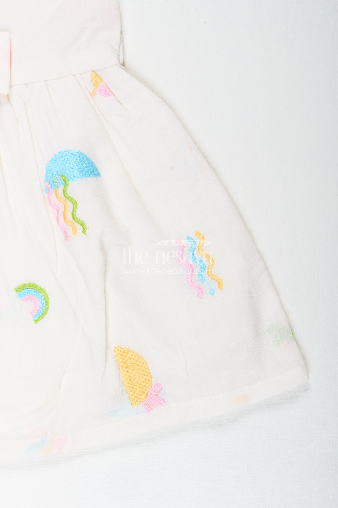 The Nesavu Baby Cotton Frocks White baby girl frock with pastel embroidery for everyday wear Nesavu Nesavu white baby girl frock with pastel rainbow embroidery and flutter sleeves for casual wear