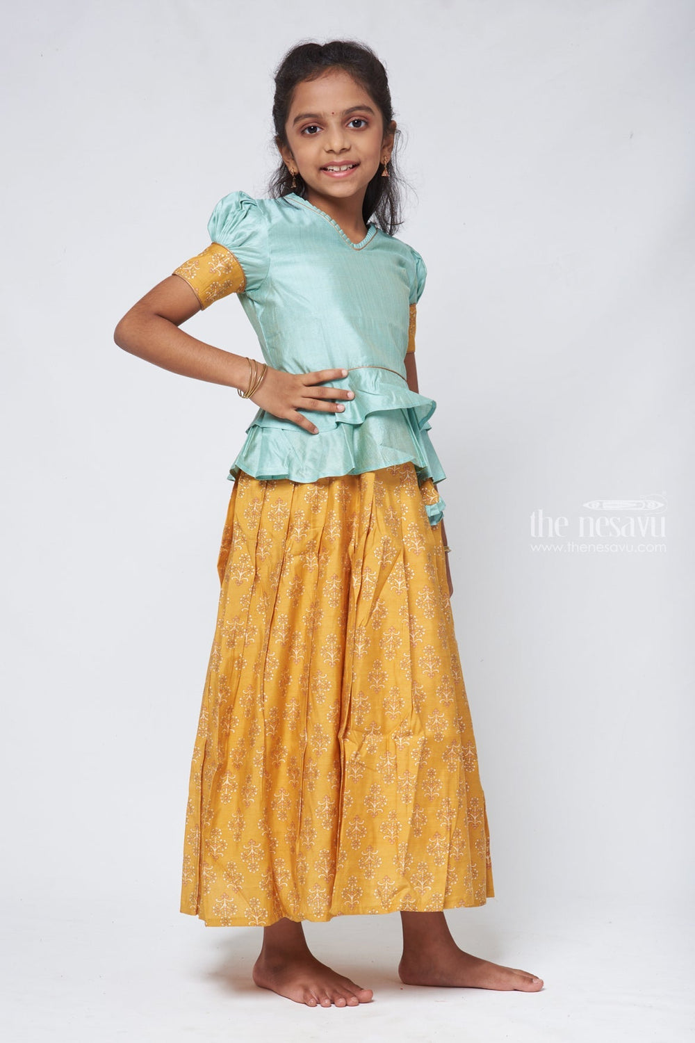 The Nesavu Pattu Pavadai Zari with Floral Printed Yellow Pleated Skirt and Green Jacquard Peplum Blouse Nesavu Latest Style Pattu Pavadai Design | Silk Readymade Dress for Girls | The Nesavu